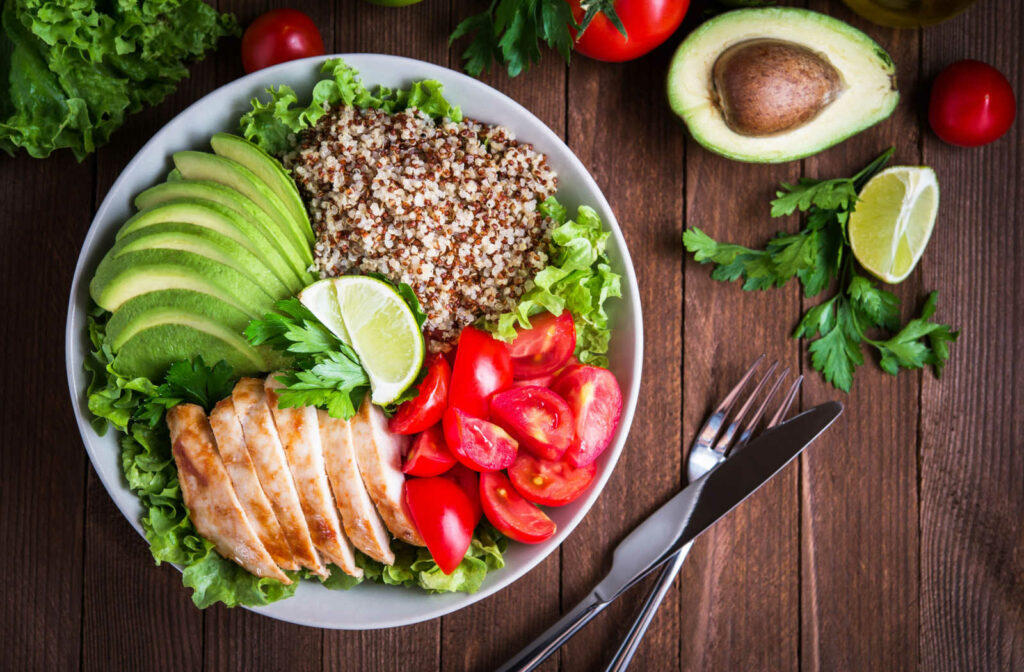 A plate with healthy foods like avocados, chicken, tomatoes, lettuce and lime to squeeze. Healthy food is meant to help seniors boost not only their physical health but their mental health.