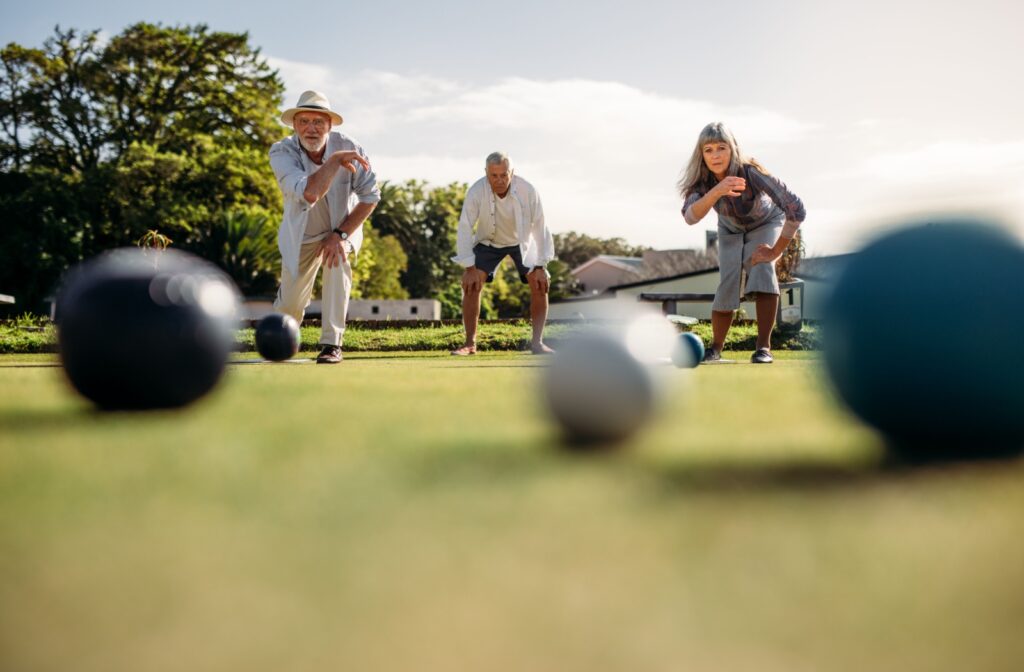 3 seniors play bocce ball on a beautiful summer afternoon in their community.